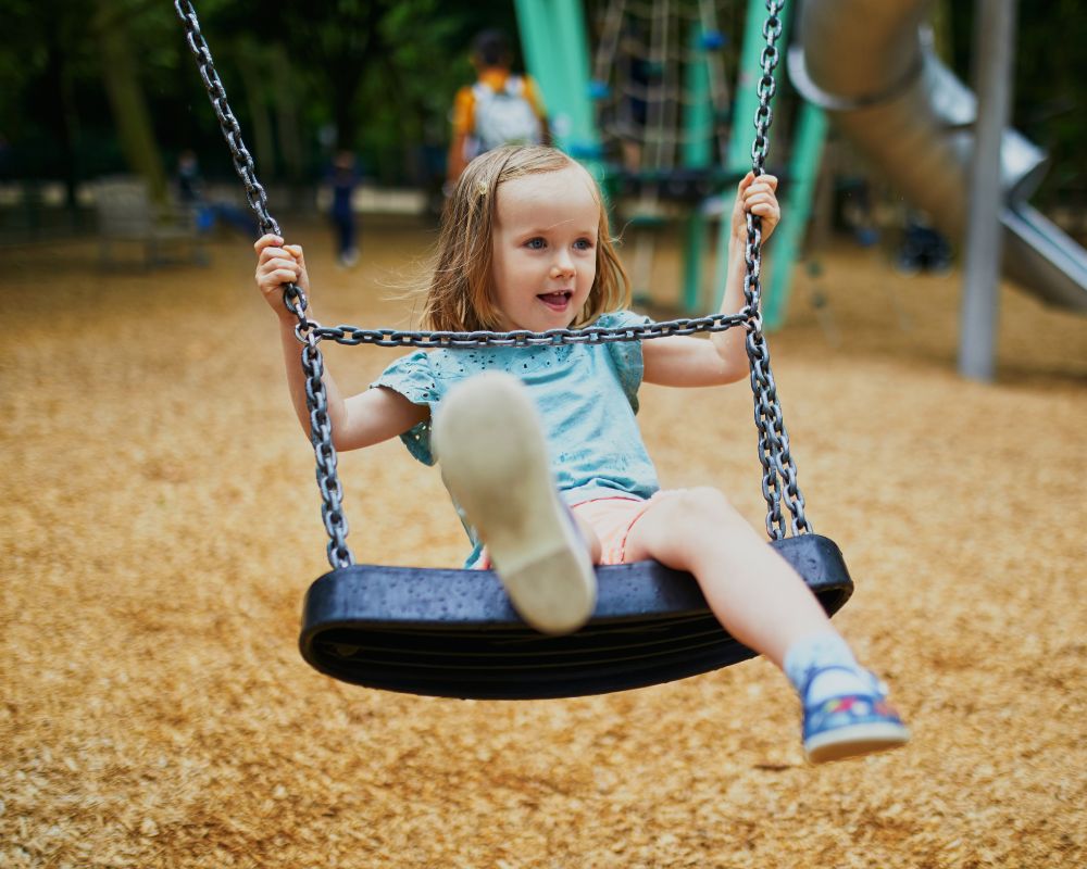 4 year old on a swing at a playground