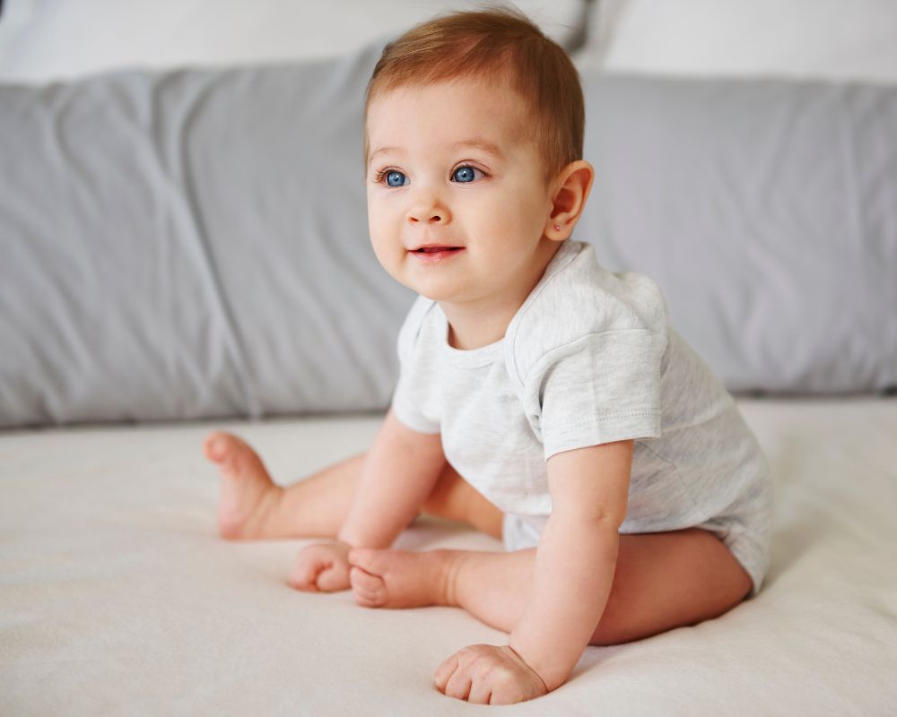 6 month old sitting up on bed