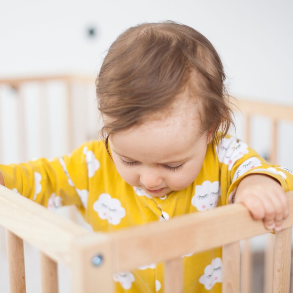 Baby looking at crib 