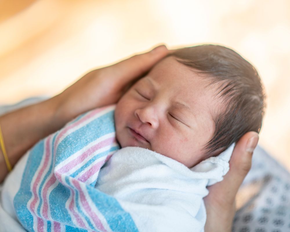 newborn swaddled in hospital blanket