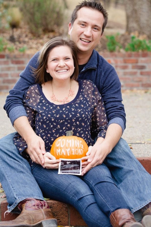 Halloween pregnancy announcement - couple holding pumpkin and ultrasound photo
