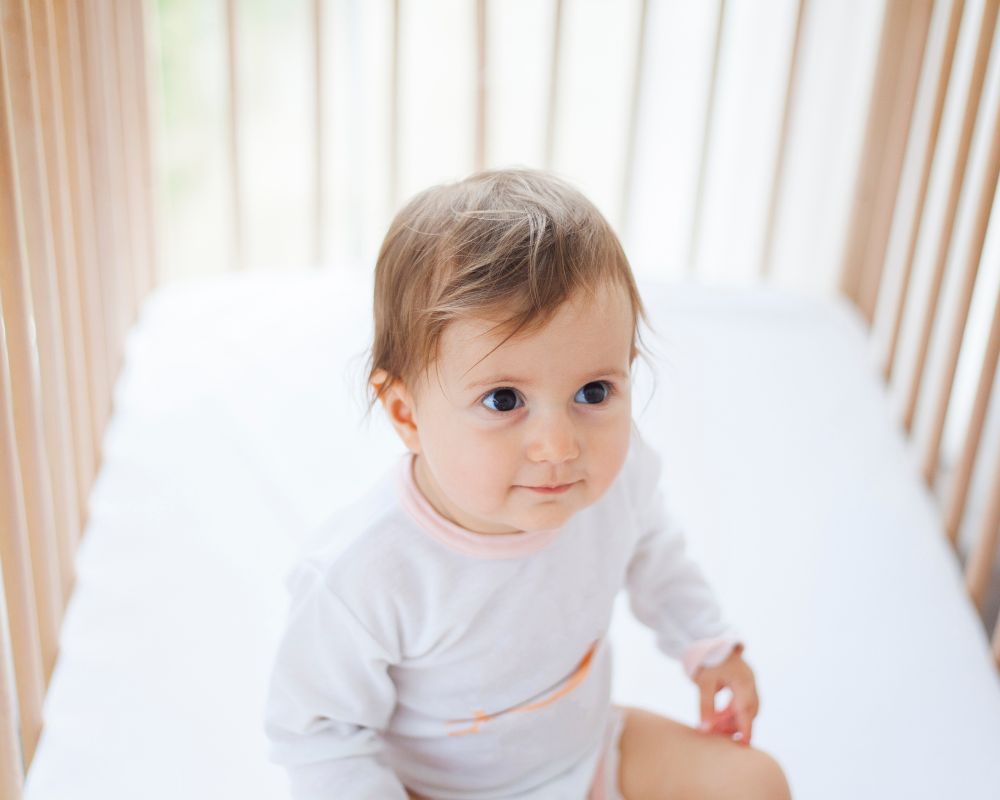 baby sitting in a crib