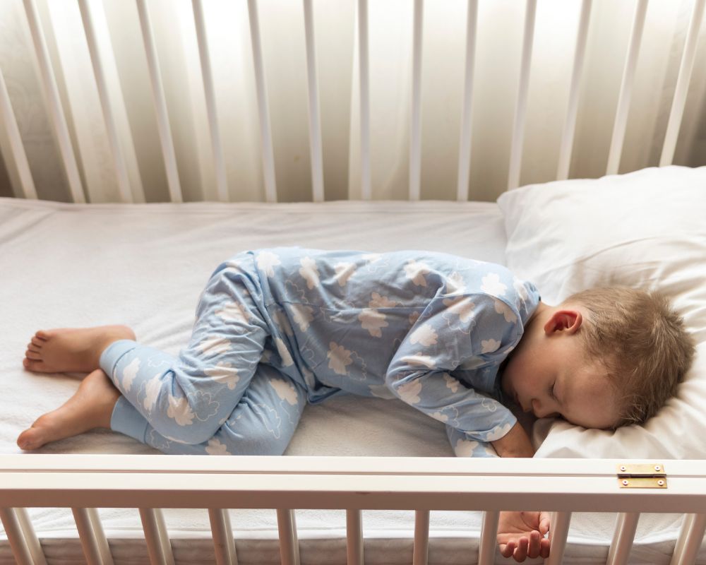 toddler sleeping in crib in the early morning