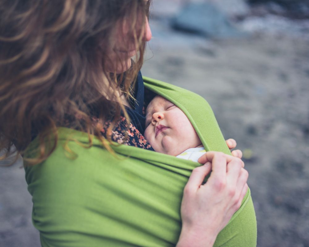 baby taking a contact nap on mom in a baby sling