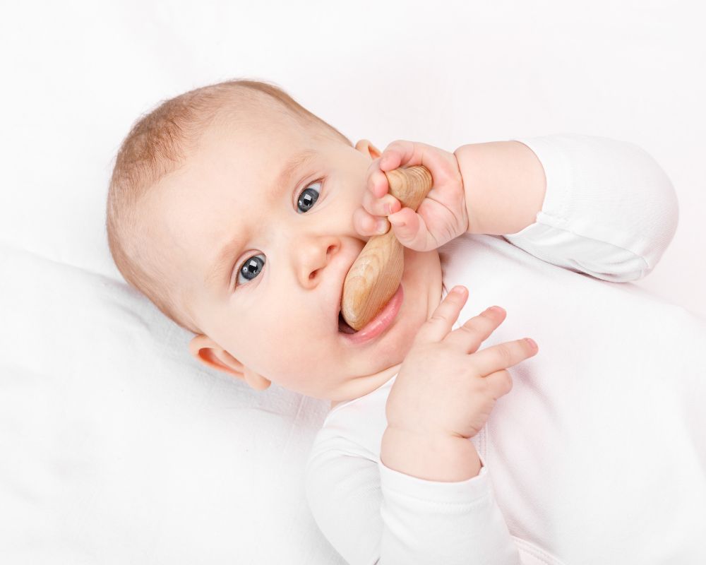 baby chewing on teething toy