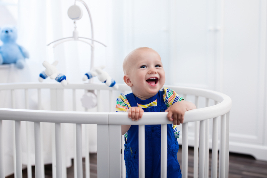 baby standing in crib, smiling, instead of taking nap