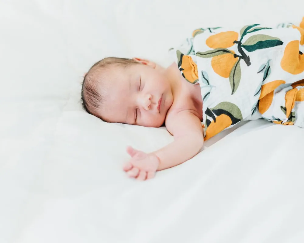 baby swaddled with one arm out