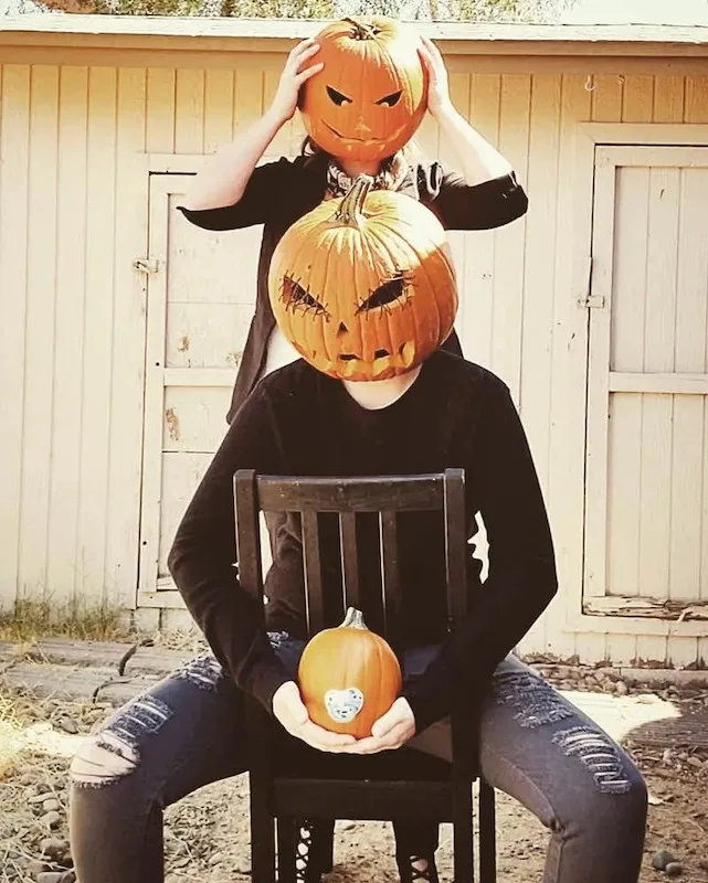 couple wearing jack o lanterns and announcing their pregnancy