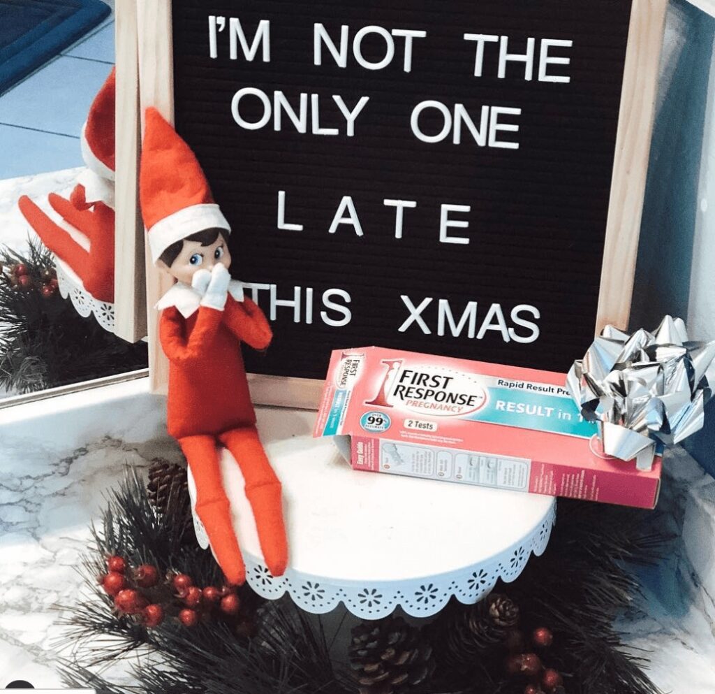 Elf on the shelf covering mouth for a funny pregnancy announcement