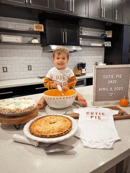 toddler boy stirring pumpkin pie announcing new baby