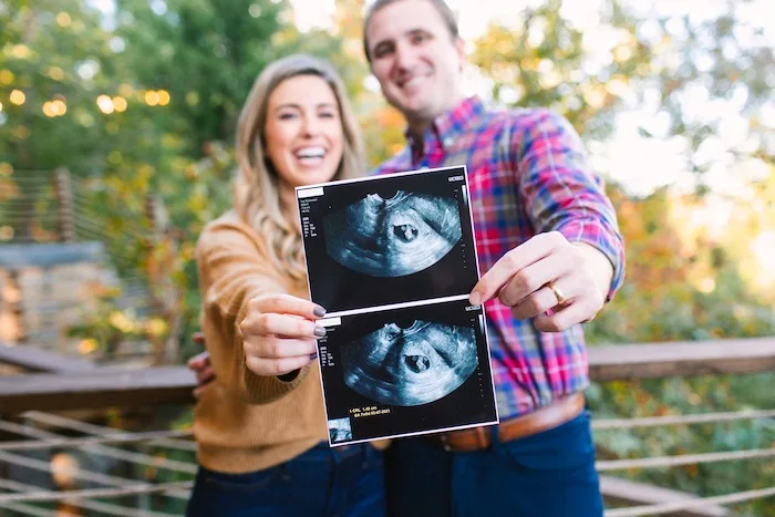 couple holding up ultrasound photo to announce pregnancy