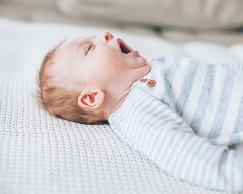 newborn yawning while laying down