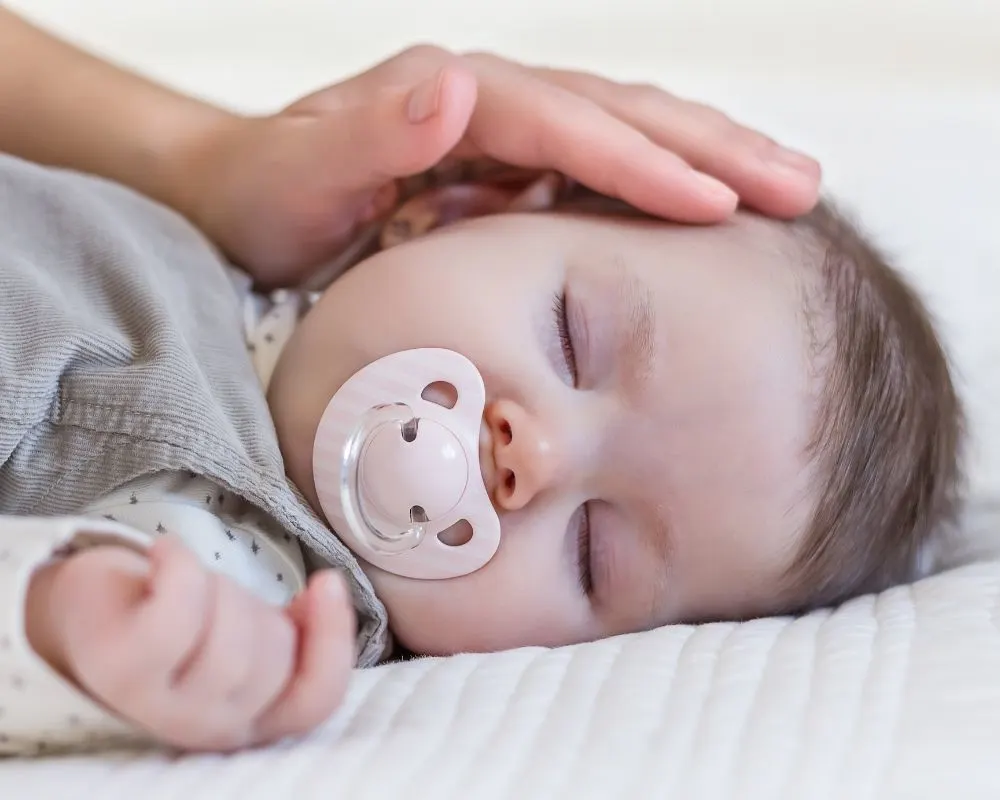 sleeping baby with a pacifier, which can be one of the soothing ladder rungs