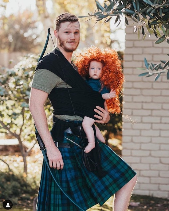 Brave baby wearing Halloween costume with dad and baby