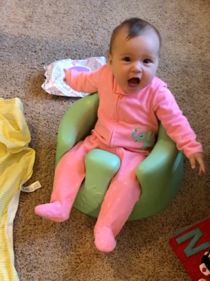 baby girl sitting in s bumbo chair