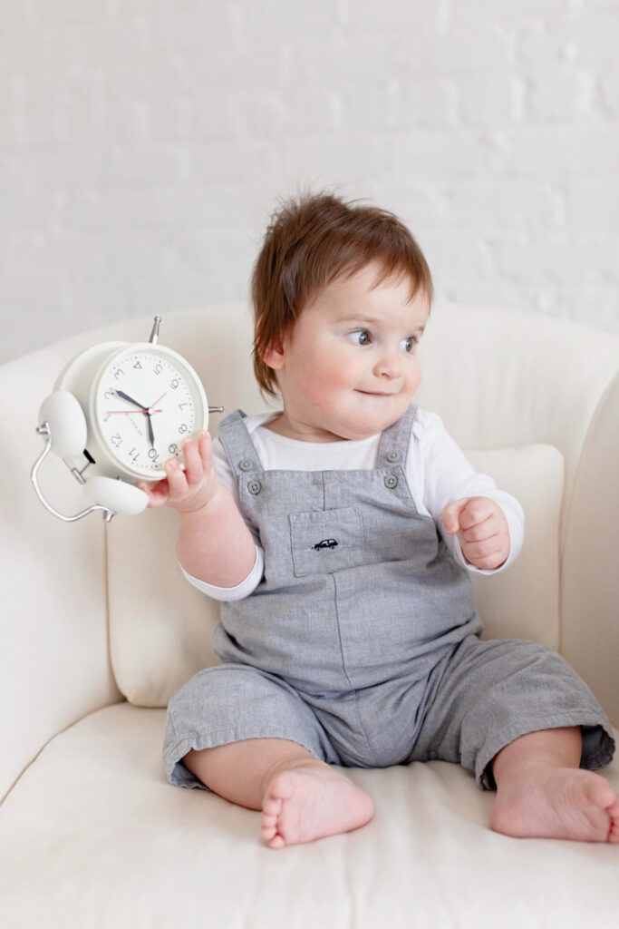 baby holding a clock